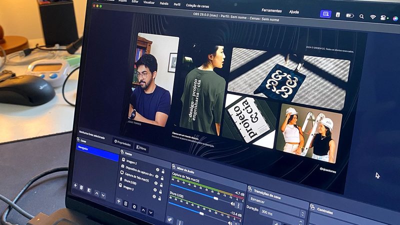 Notebook com um vídeo em edição, ao lado da câmera e do microfone