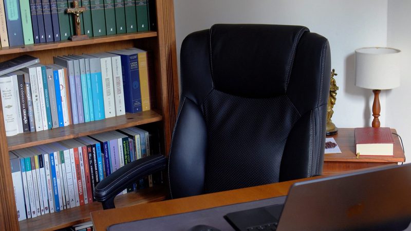 Estante de livros ao lado da cadeira do escritório
