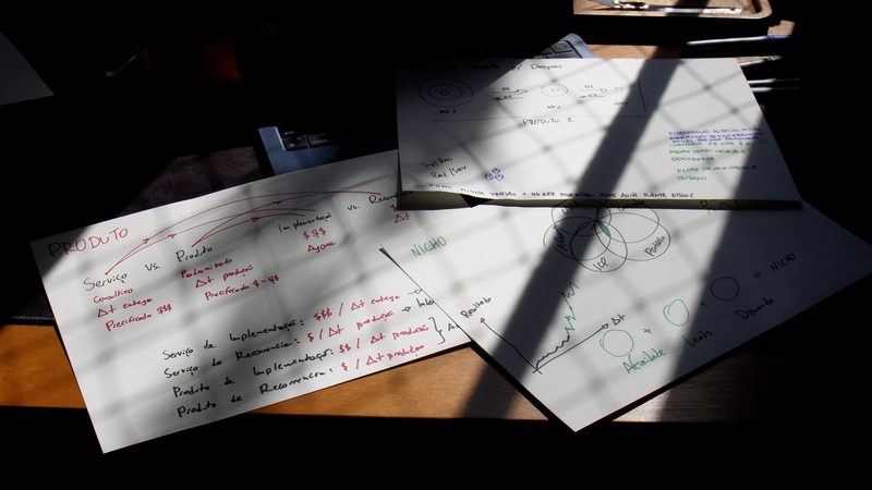 Folhas de planejamento com contas sobre a mesa, com luz e sombra da janela